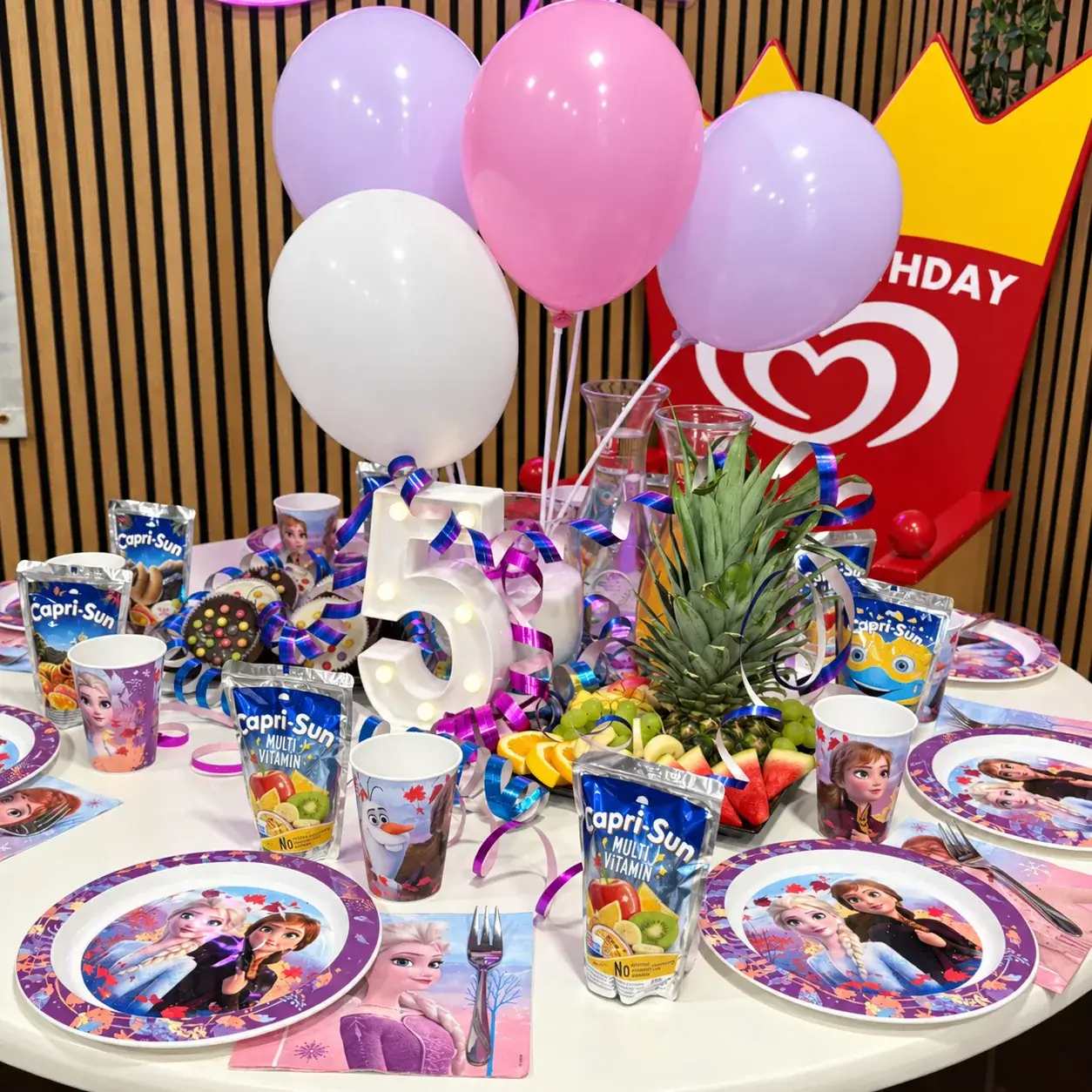 Geburtstagstisch zum fünften Kindergeburtstag mit Frozen-Geschirr, Luftballons und Obst im Kindercafé Spielzimmer in Berlin