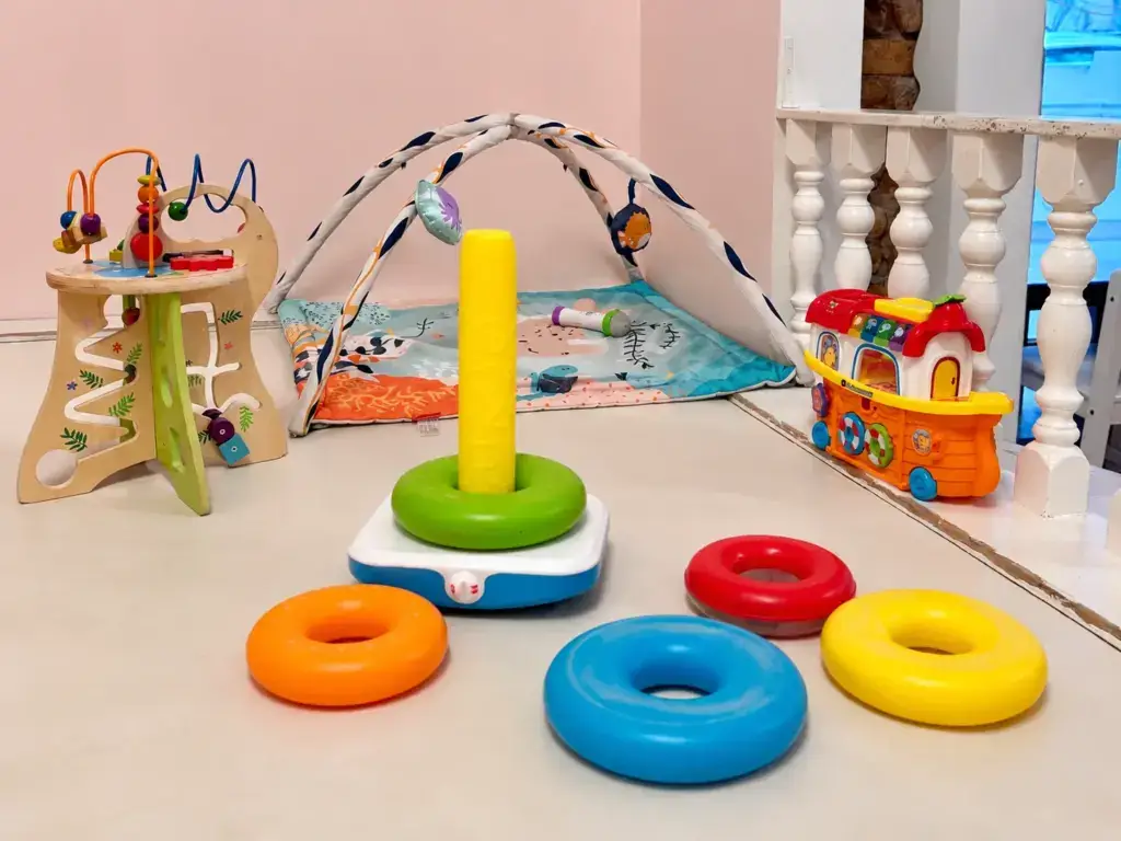 Kleinkindbereich im KindercafeSpielzimmer. Auf dem Boden liegen Stapelringe.